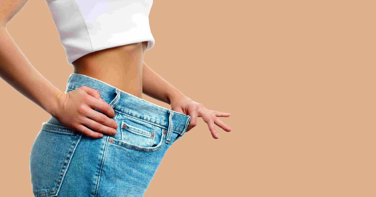 Woman showing weight loss success by wearing loose jeans after treatment with GLP-1 in Severna Park, MD